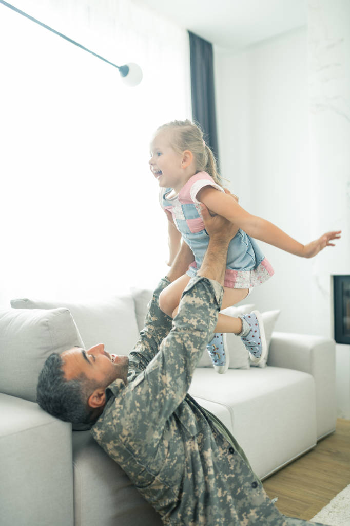 Man komt terug naar huis na militaire dienst spelen met dochter - Foto, afbeelding