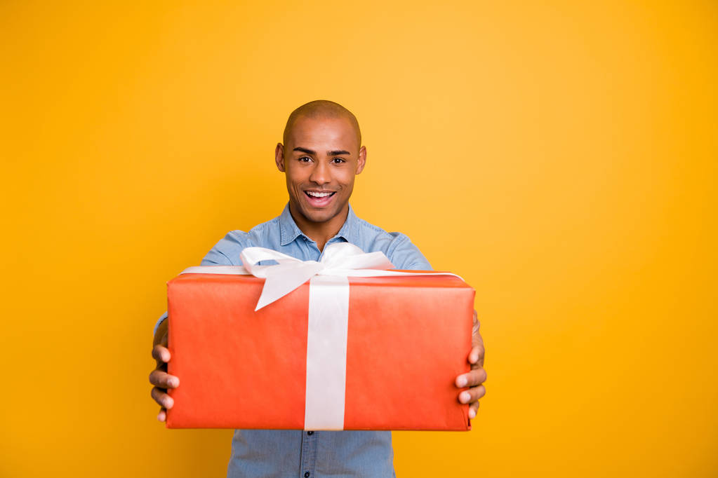 Retrato de hombre amigable lindo celebrar caja de regalo de la mano cinta roja blanca aislado sobre fondo amarillo
 - Foto, imagen