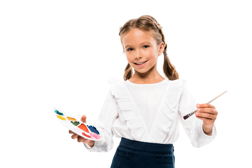 positieve Kid Holding kleurrijke aquarel palet geïsoleerd op wit  - Foto, afbeelding
