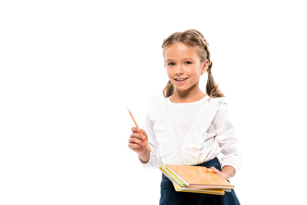 χαρούμενο παιδί που κρατά βιβλία και μολύβι απομονωμένο σε λευκό  - Φωτογραφία, εικόνα