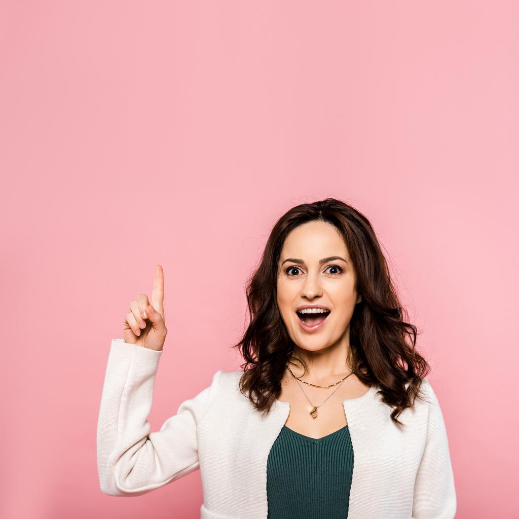excited woman pointing with finger isolated on pink  - Photo, Image