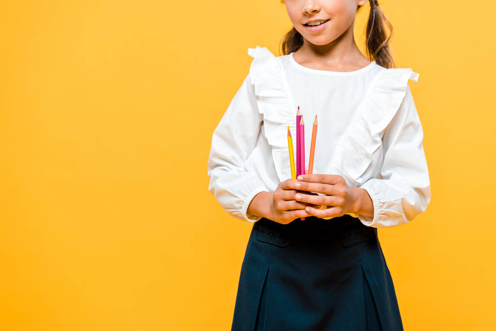 обрезанный вид счастливого школьника с цветными карандашами изолированы на оранжевый
  - Фото, изображение