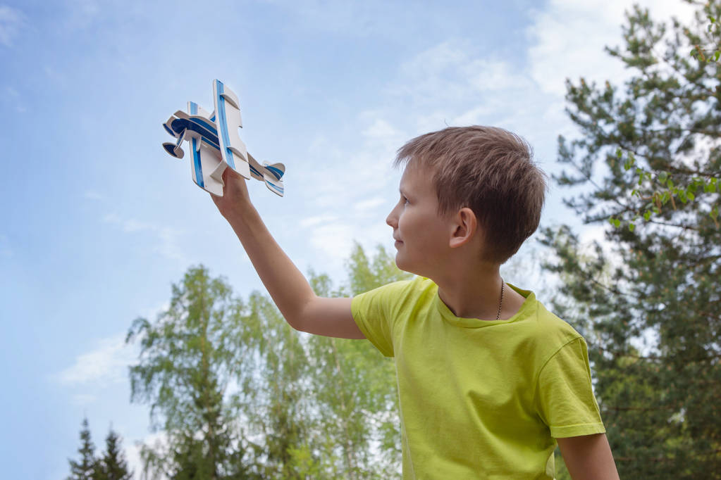 Een jongen met een vliegtuig tegen de hemel met wolken. Heldere emoties. Levensstijl. Zomer Mood. - Foto, afbeelding