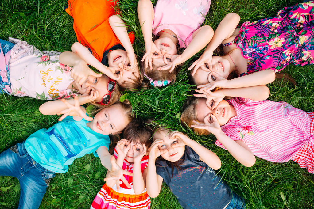 Un gruppo di bambini sdraiati sull'erba verde del Parco. L'interazione dei bambini. - Foto, immagini