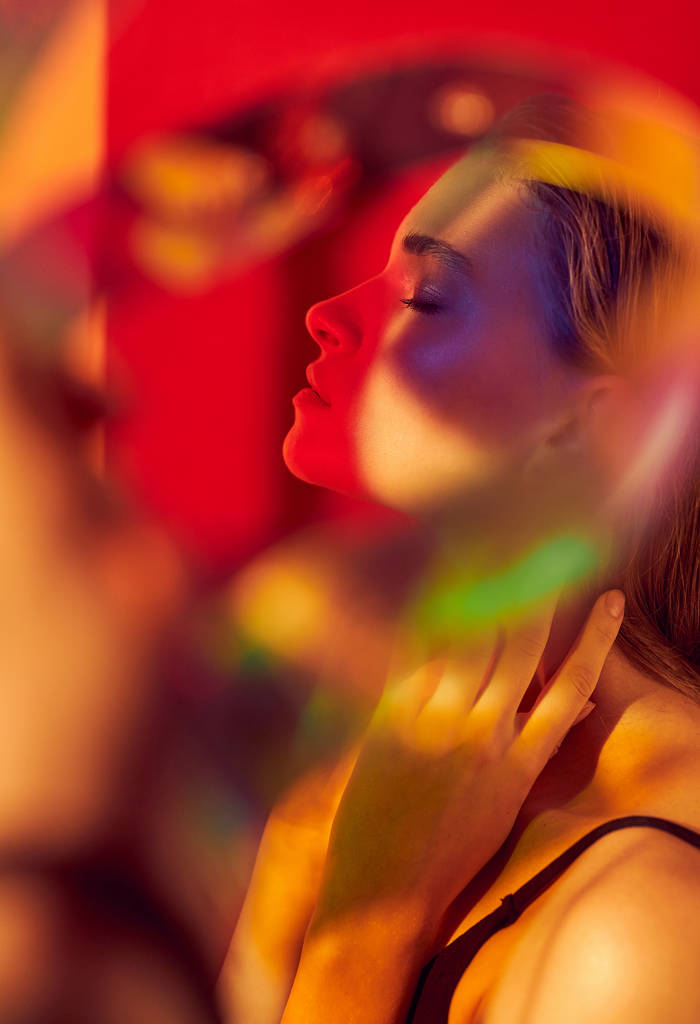 Портрет модного мистецтва молодої і сексуальної жіночої моделі, що позує в різнокольорових вогнях
 - Фото, зображення