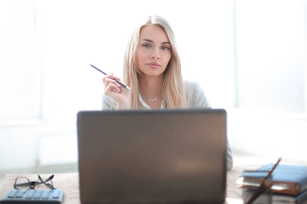 junge Geschäftsfrau sitzt an ihrem Schreibtisch - Foto, Bild