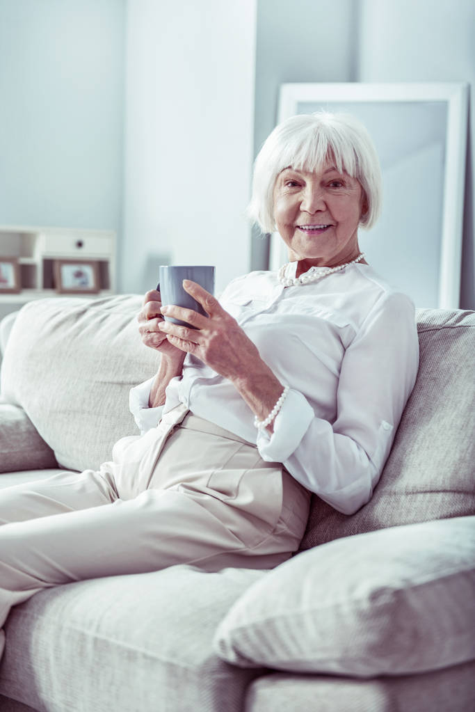 Beaming aposentado mulher sentindo-se aliviado enquanto passar o dia em casa
 - Foto, Imagem