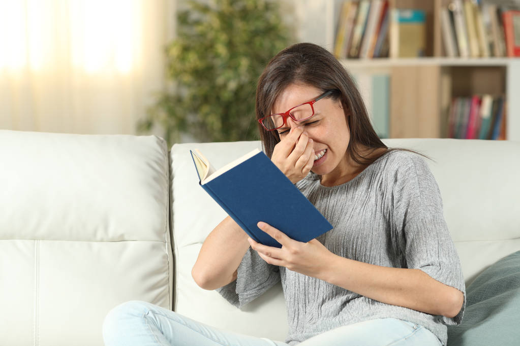 眼鏡をかけた女性は、本を読んで目を苦しめています - 写真・画像