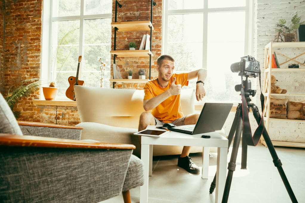 Caucásico blogger masculino con cámara de grabación de vídeo de revisión de gadgets en casa
 - Foto, Imagen
