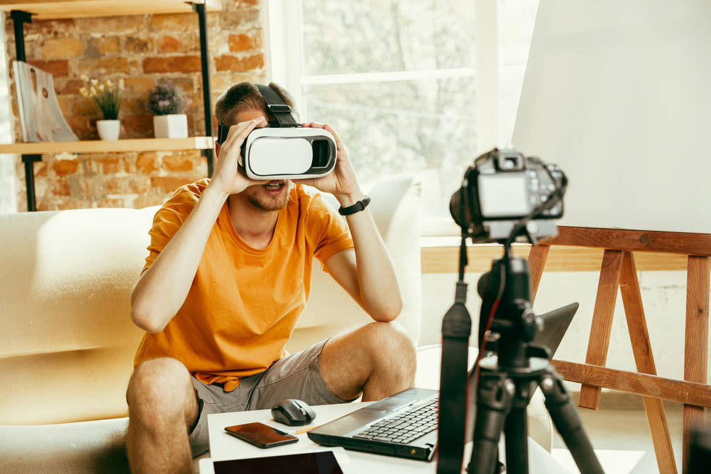 Καυκάσιος αρσενικό blogger με κάμερα εγγραφή βίντεο ανασκόπηση των gadget στο σπίτι - Φωτογραφία, εικόνα