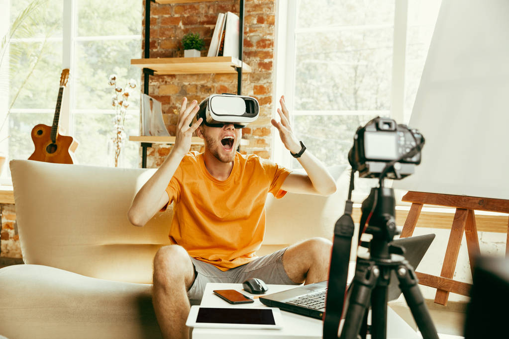 Caucásico blogger masculino con cámara de grabación de vídeo de revisión de gadgets en casa
 - Foto, imagen