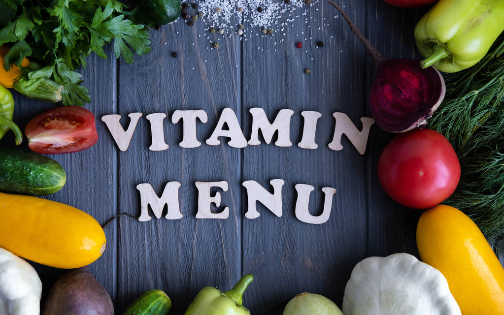 Konzeptfoto mit der Aufschrift Vitaminmenü. grauen Hintergrund mit Gemüse nützlich für Gesundheit und Ernährung. Vegetarismus, richtige Ernährung und Gewichtsverlust - Foto, Bild