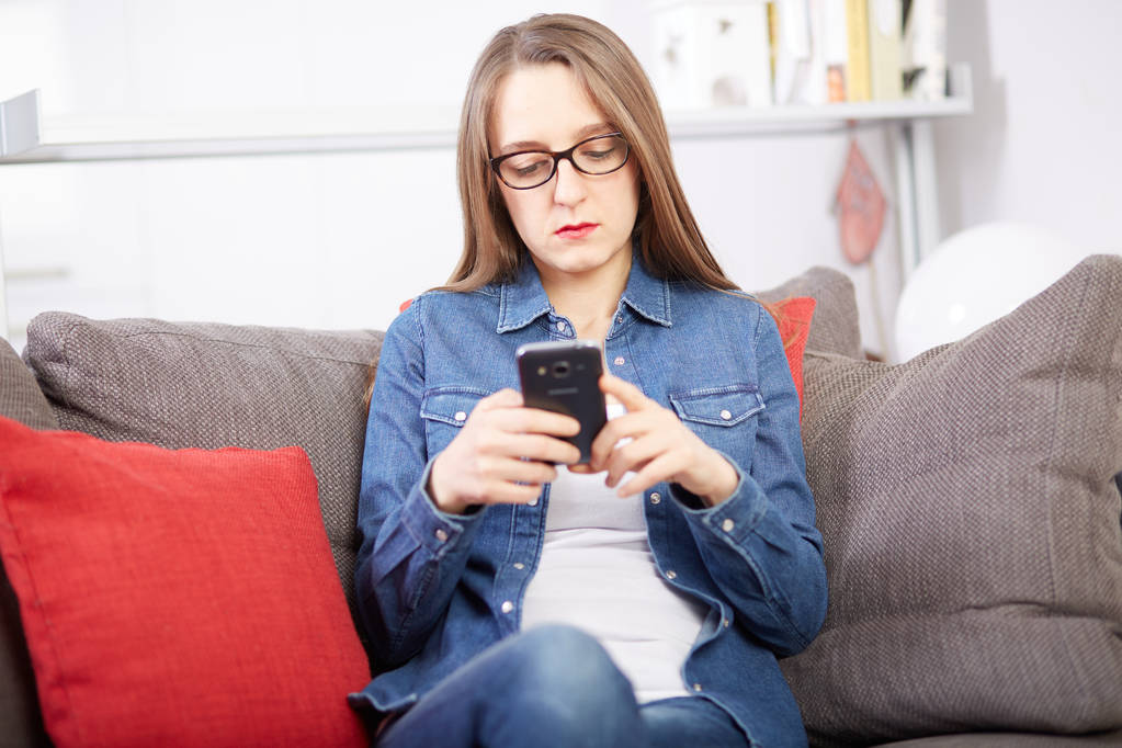 mulher conversando com celular no sofá
 - Foto, Imagem