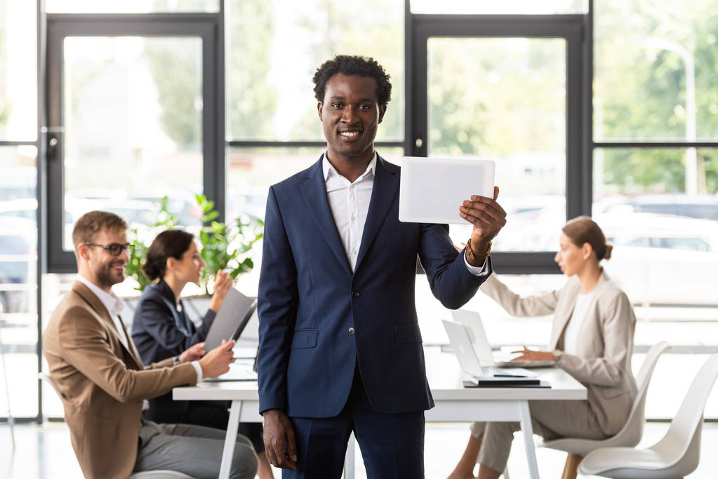 vue de face de l'homme d'affaires afro-américain en tenue formelle tenant tablette numérique au bureau
 - Photo, image