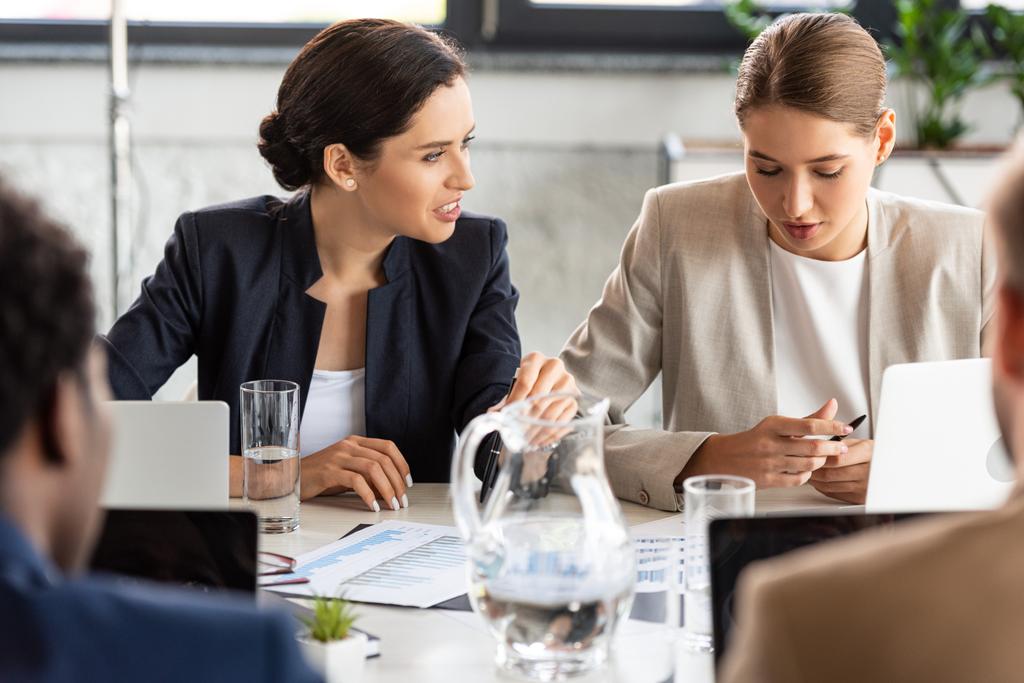 частичный взгляд бизнесменов в формальной одежде за столом во время конференции в офисе
 - Фото, изображение