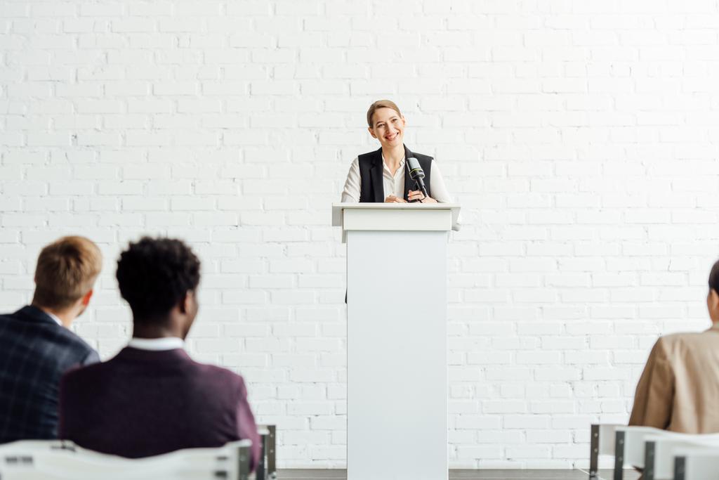 приваблива бізнес-леді стоячи і посміхаючись під час конференц-залу
 - Фото, зображення