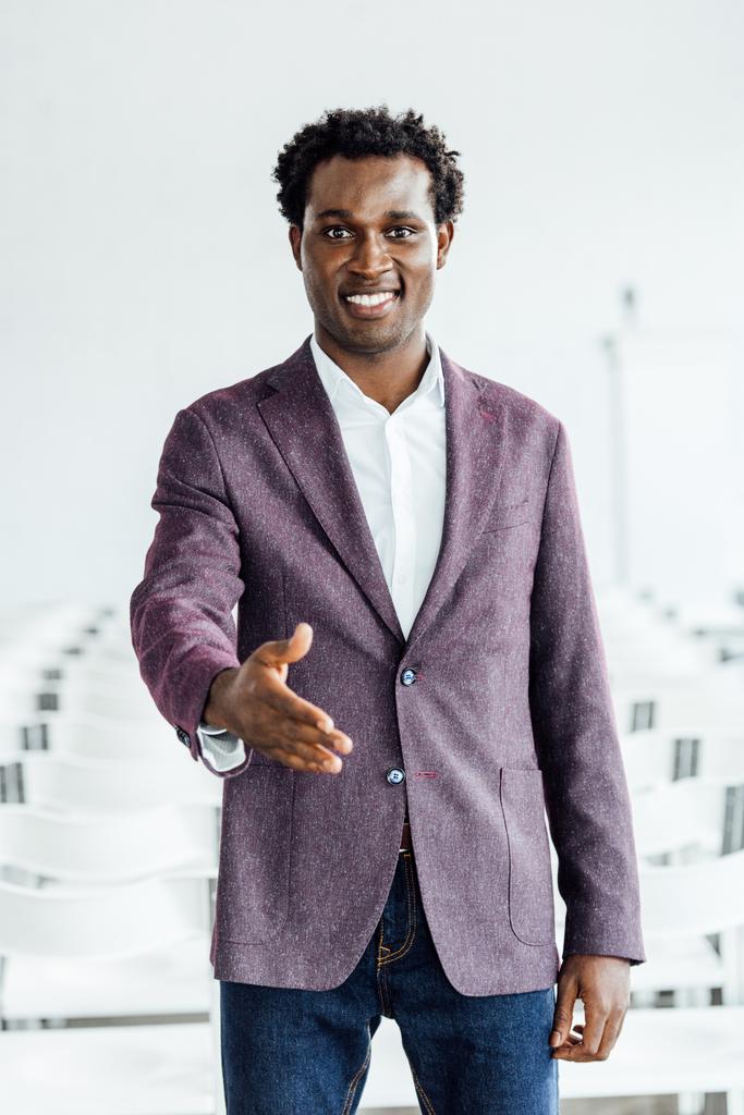 афроамериканець бізнесмен в офіційному зносу з витягнутих боку посміхаючись у конференц-залі - Фото, зображення