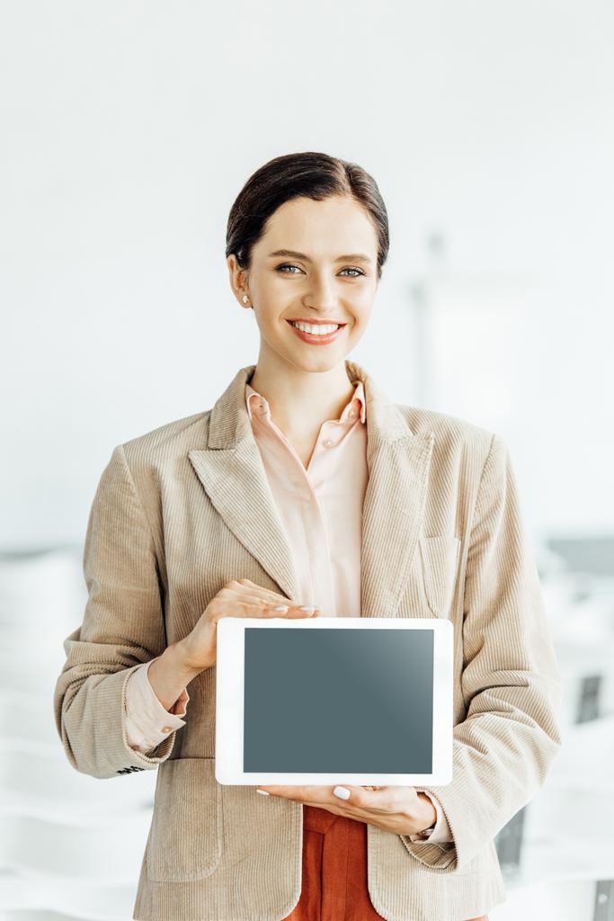 attractive businesswoman in formal wear smiling and holding digital tablet  - Photo, Image