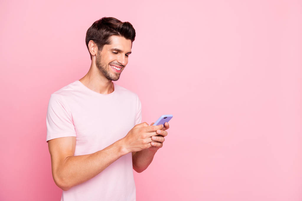 Профіль вид збоку портрет його він привабливий веселий веселий концентрований хлопець тримає в руках пристрій веб-серфінгу, використовуючи службу знайомств ізольовані на рожевому пастельному фоні
 - Фото, зображення