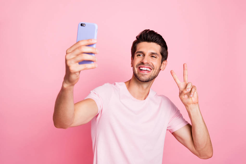 Portrait of his he nice attractive lovely cheerful cheery confident guy taking making selfie showing v-sign free time isolated over pink pastel background - Photo, Image