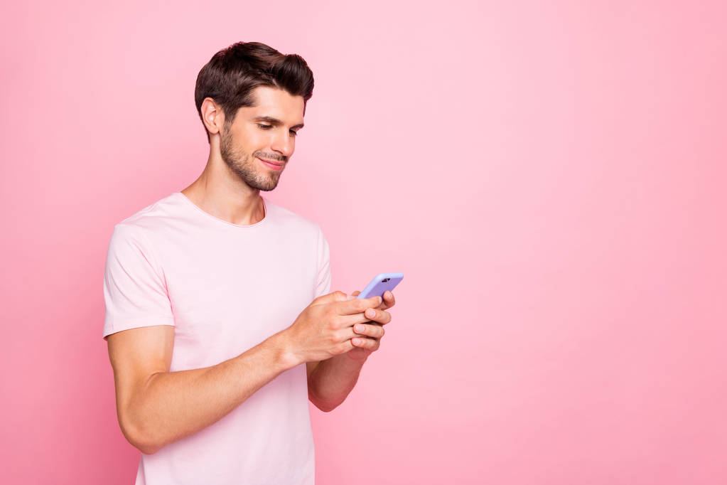 Profiel zijaanzicht portret van zijn hij mooie aantrekkelijke vrolijke vrolijk gefocuste kerel vasthouden in handen apparaat gadget web surfen geïsoleerd over roze pastel achtergrond - Foto, afbeelding