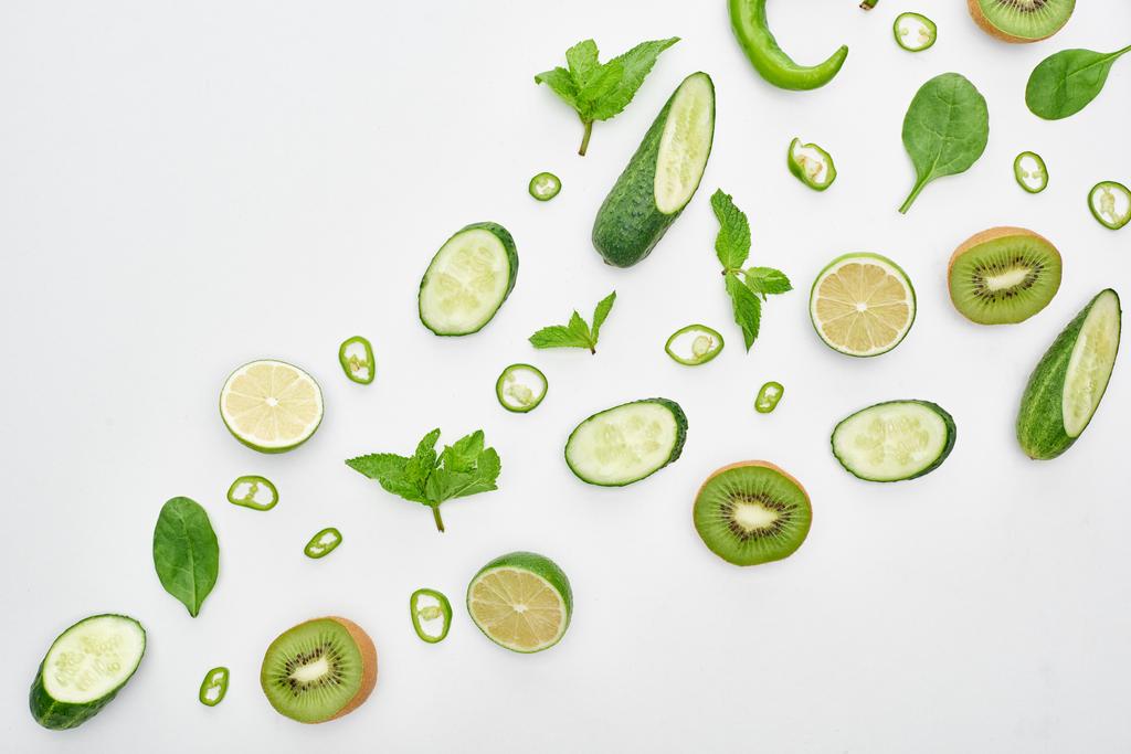  top view of fresh cucumbers, kiwi, limes, peppers and greenery  - Photo, Image