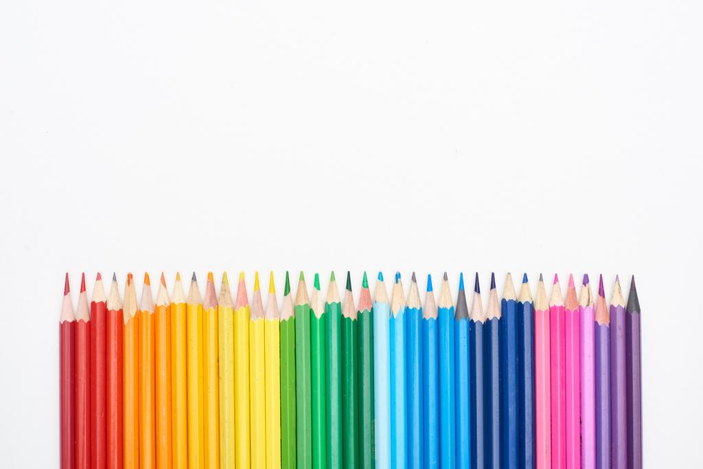 Spectre arc-en-ciel composé d'une rangée droite de crayons de couleur isolés sur du blanc
 - Photo, image