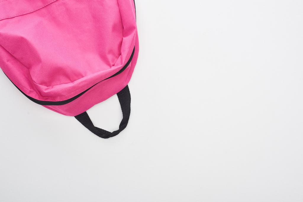 Κορυφαία θέα από φωτεινή ροζ σχολική τσάντα απομονώθηκε σε λευκό - Φωτογραφία, εικόνα