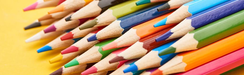 Sharpened ends of color pencils on yellow background - Photo, Image