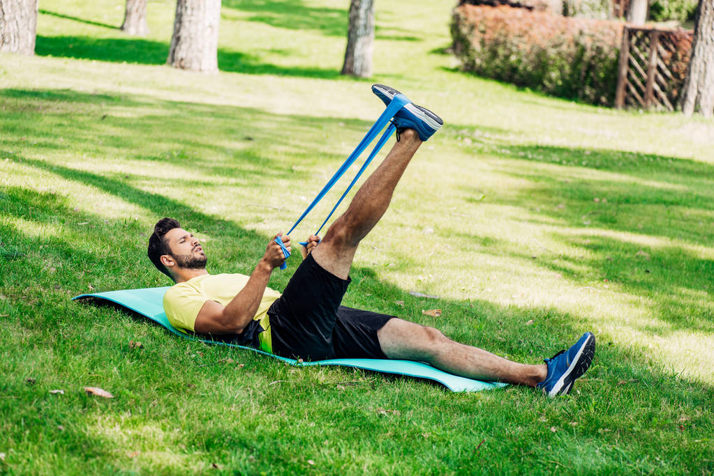 γένια άνθρωπος άσκηση με ιμάντες ανάρτησης, ενώ βρίσκεται σε χαλάκι γυμναστικής  - Φωτογραφία, εικόνα