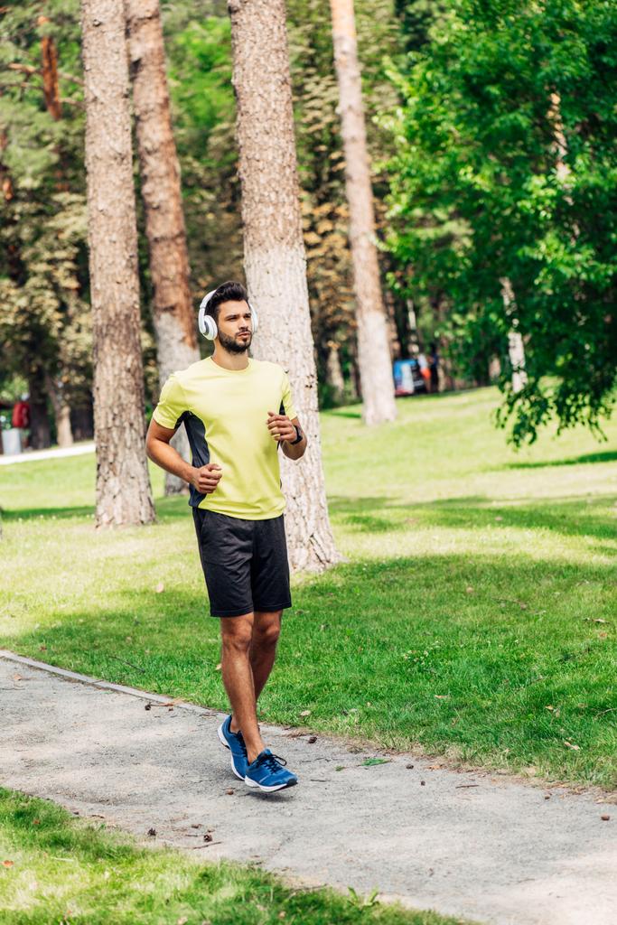 handsome bearded man running while listening music in headphones  - Photo, Image