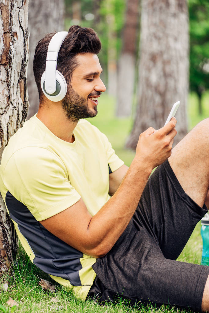 boldog ember hallgat zenét, és segítségével okostelefon Park  - Fotó, kép