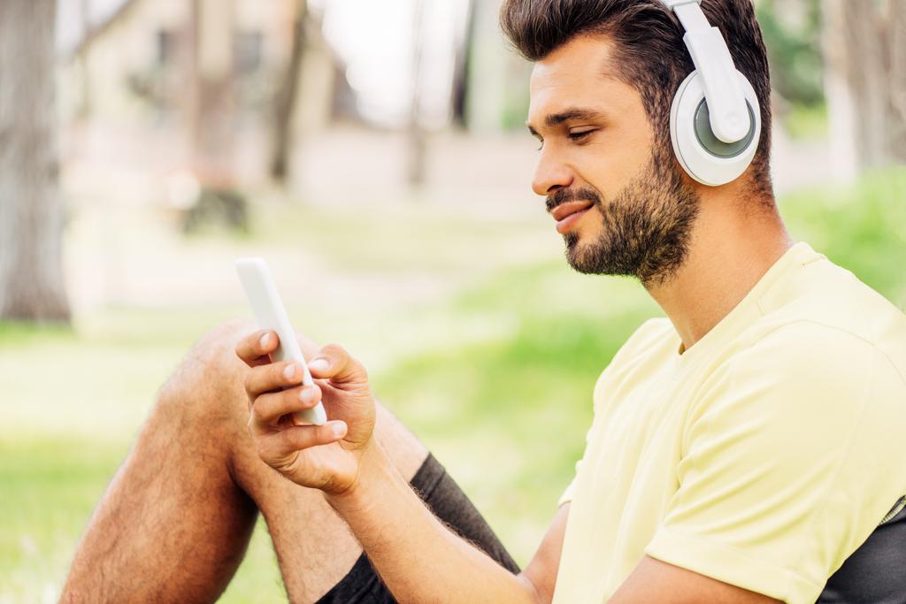 boldog szakállas ember hallgató zene és használ smartphone  - Fotó, kép