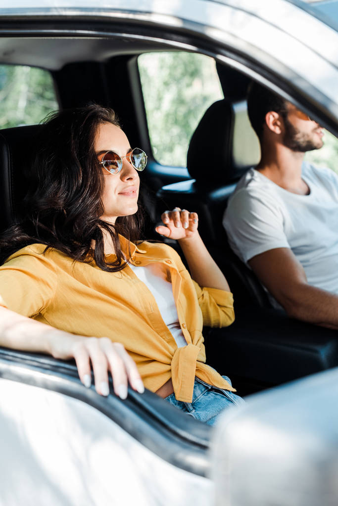 селективный фокус привлекательной девушки рядом с водителем в автомобиле
  - Фото, изображение