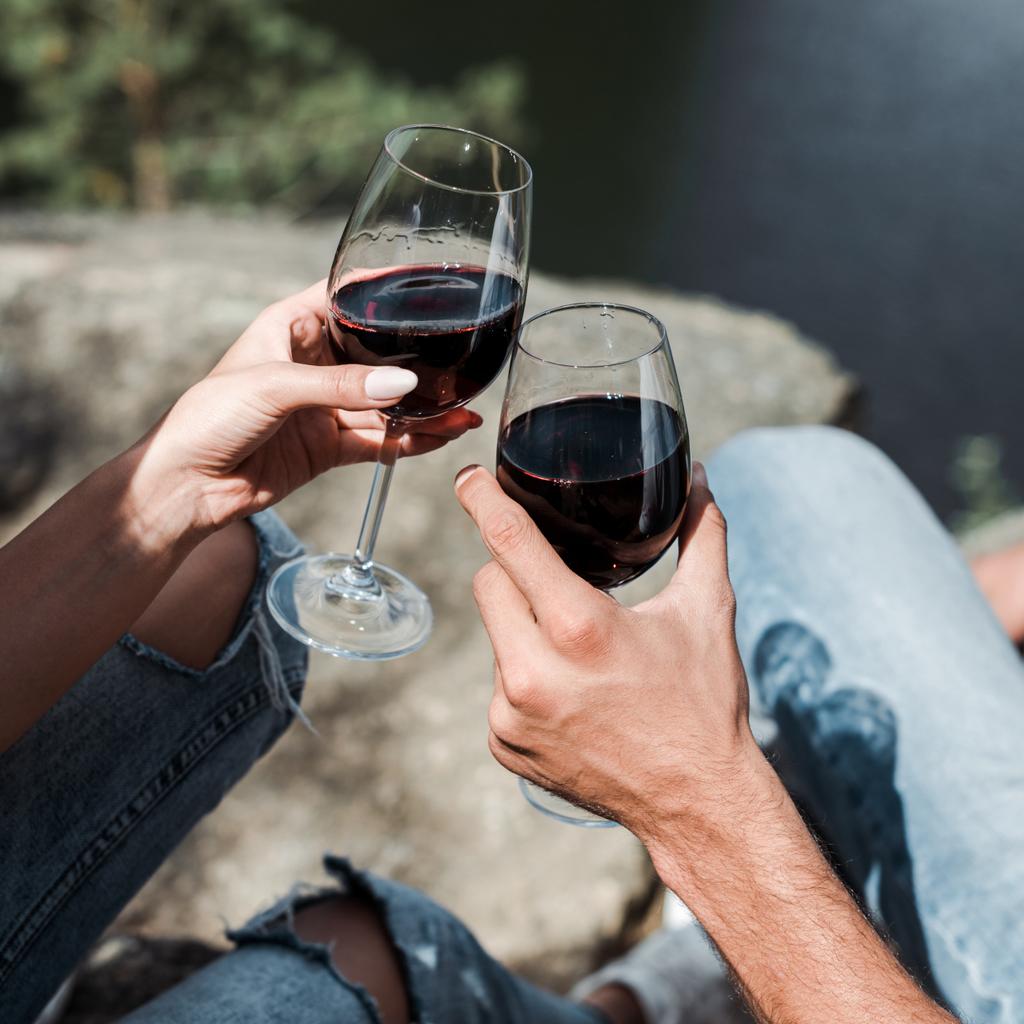 vista cortada de homem e jovem mulher clinking copos de vinho
  - Foto, Imagem