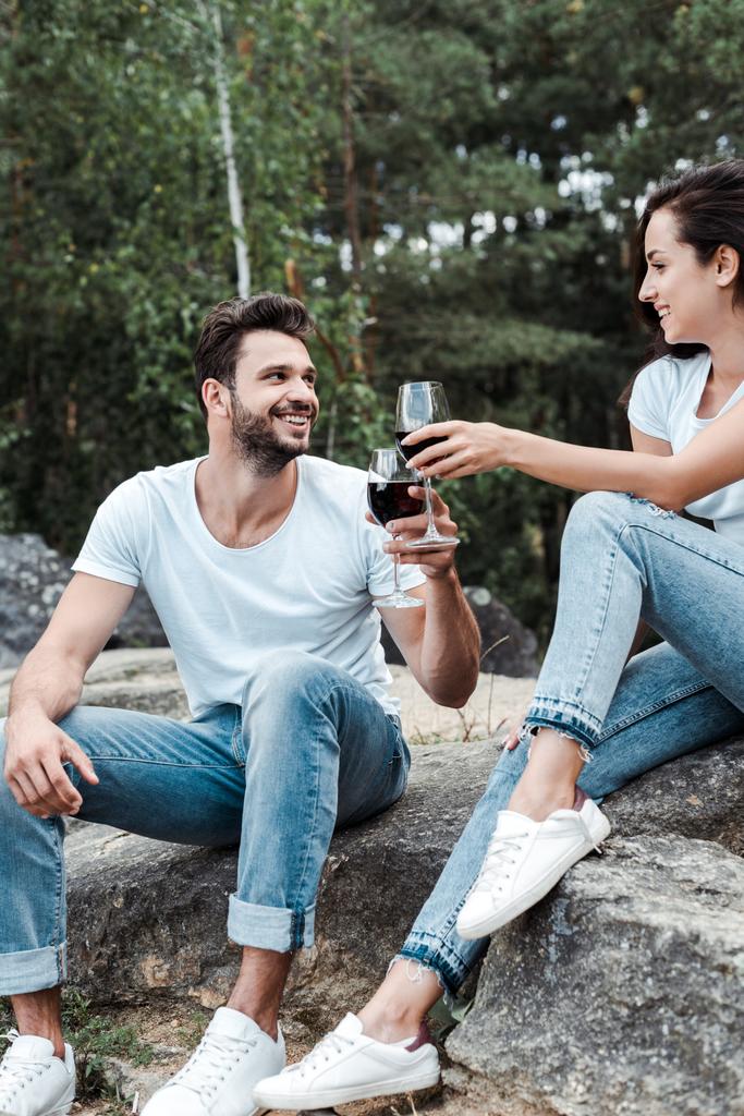 feliz hombre y joven mujer tintineo copas de vino
  - Foto, imagen