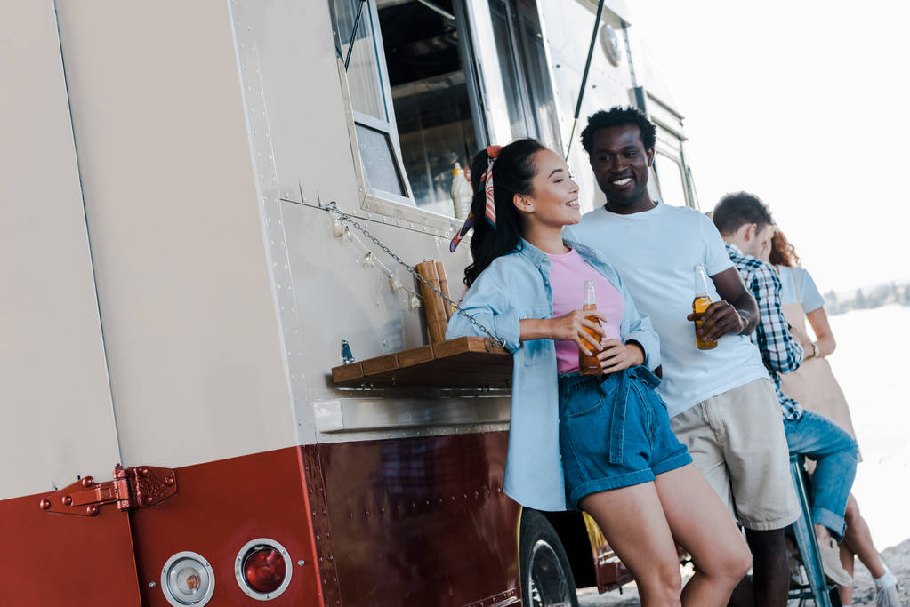 foyer sélectif de l'homme afro-américain regardant asiatique jeune femme près de camion alimentaire
  - Photo, image