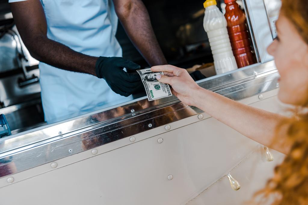 valikoiva painopiste punapää tyttö antaa rahaa afrikkalainen amerikkalainen mies ruoka kuorma
  - Valokuva, kuva