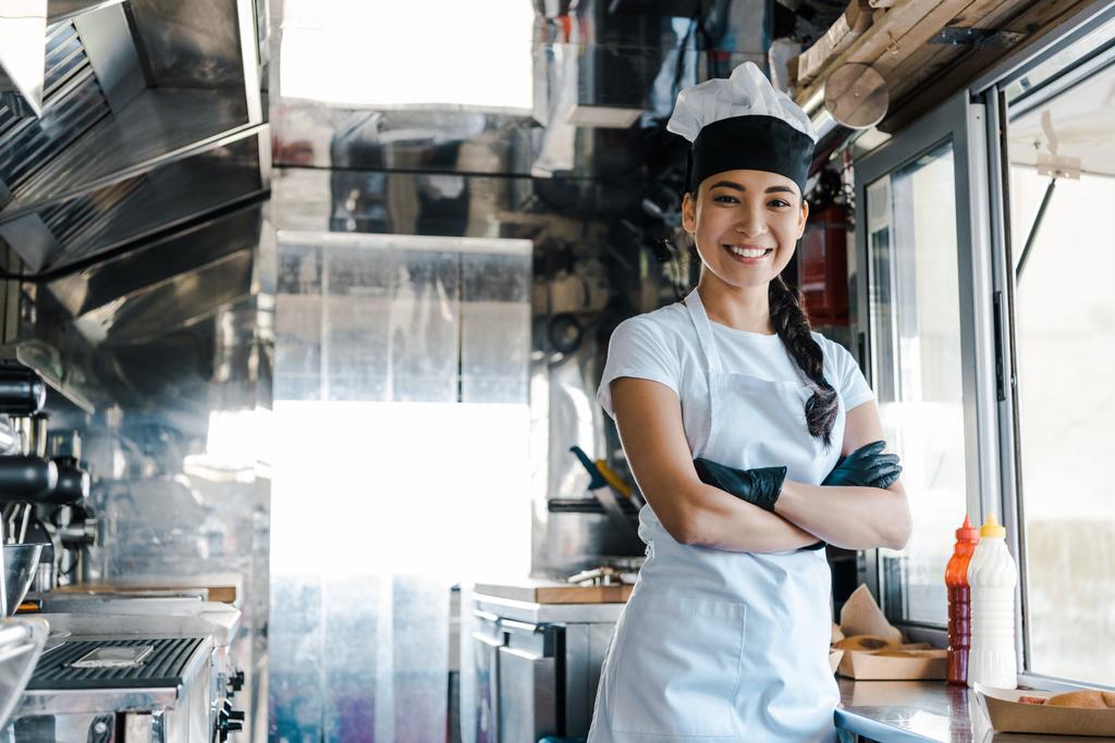 szczęśliwy Asian kobieta stojący z skrzyżowanymi ramionami w Food Truck  - Zdjęcie, obraz