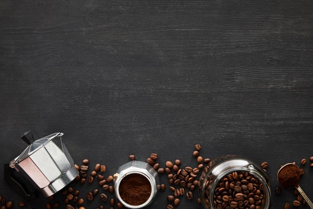 Vrchní pohled na části gejzíru kávy v blízkosti skleněného džbánu a lžíce na tmavém dřevěném povrchu s kávovými fazolemi - Fotografie, Obrázek