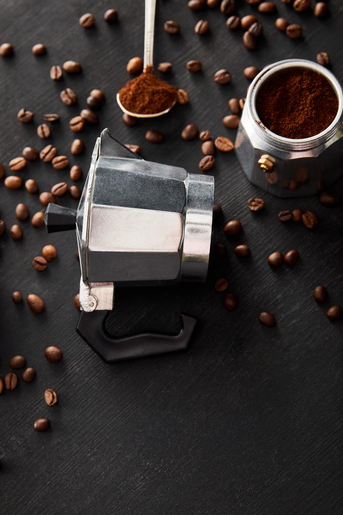 Отдельные части гейзера кофеварка возле ложки на темной деревянной поверхности с кофейными зёрнами
 - Фото, изображение