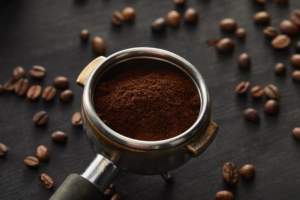 Portafilter töltött friss kávé sötét fa felületén kávébab - Fotó, kép