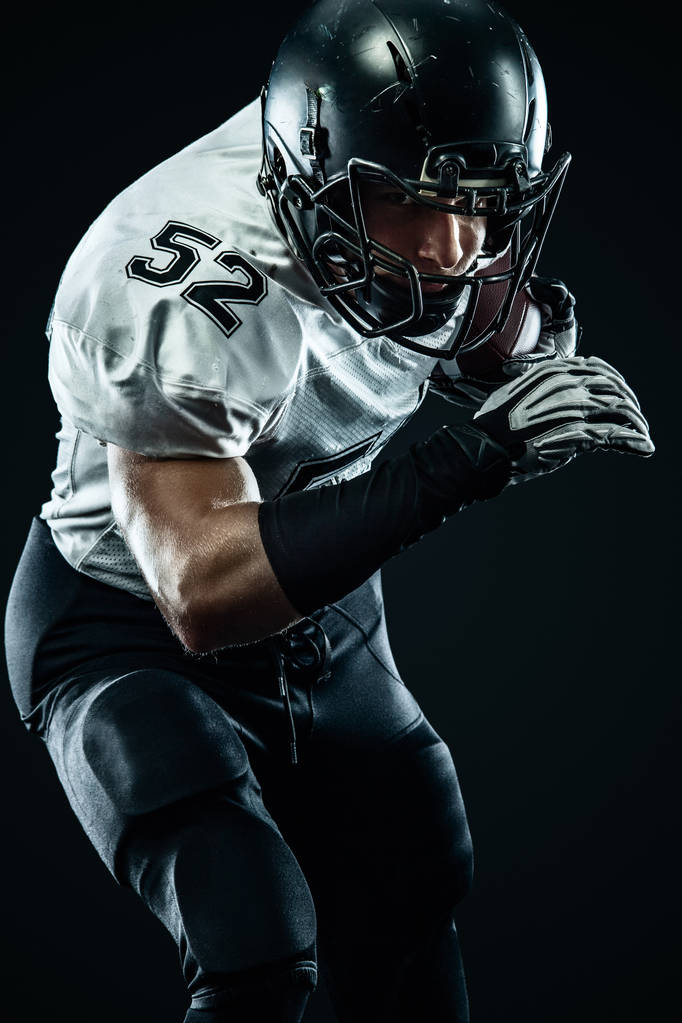 American Football Sportler mit Helm isoliert Lauf in Aktion auf schwarzem Hintergrund. Sport und Motivation Tapete. Mannschaftssport, - Foto, Bild