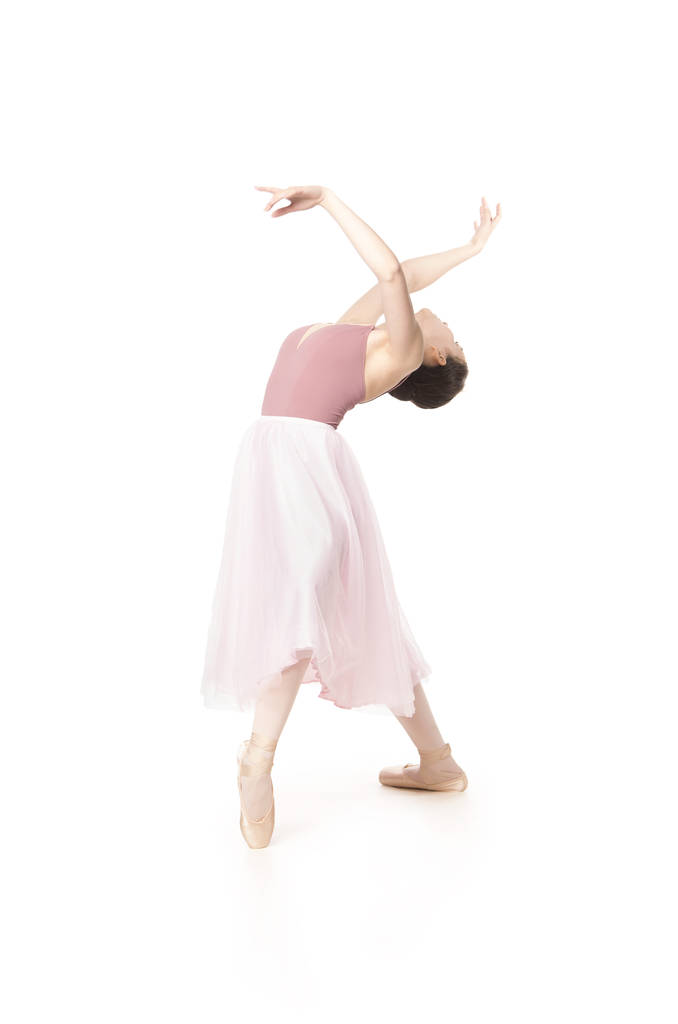 Elegant girl in a pink skirt and beige top dancing ballet. - Photo, Image