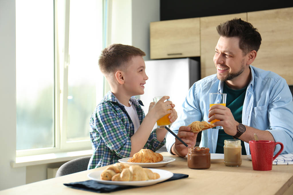 Папа и сын завтракают вместе на кухне
 - Фото, изображение