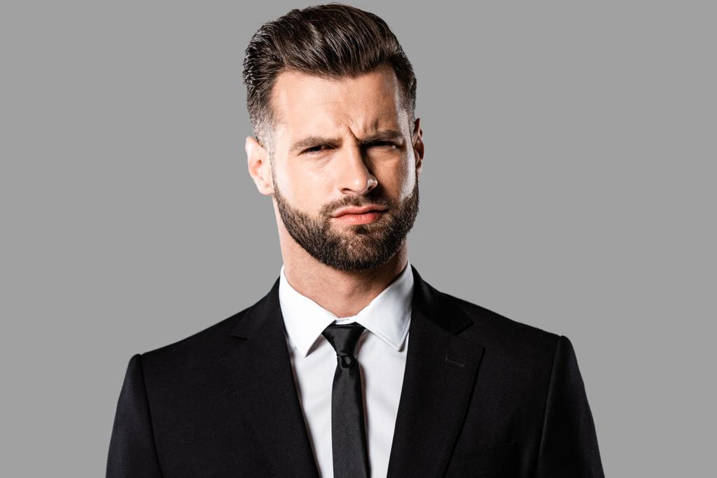 escéptico hombre de negocios guapo en traje negro aislado en gris
 - Foto, Imagen