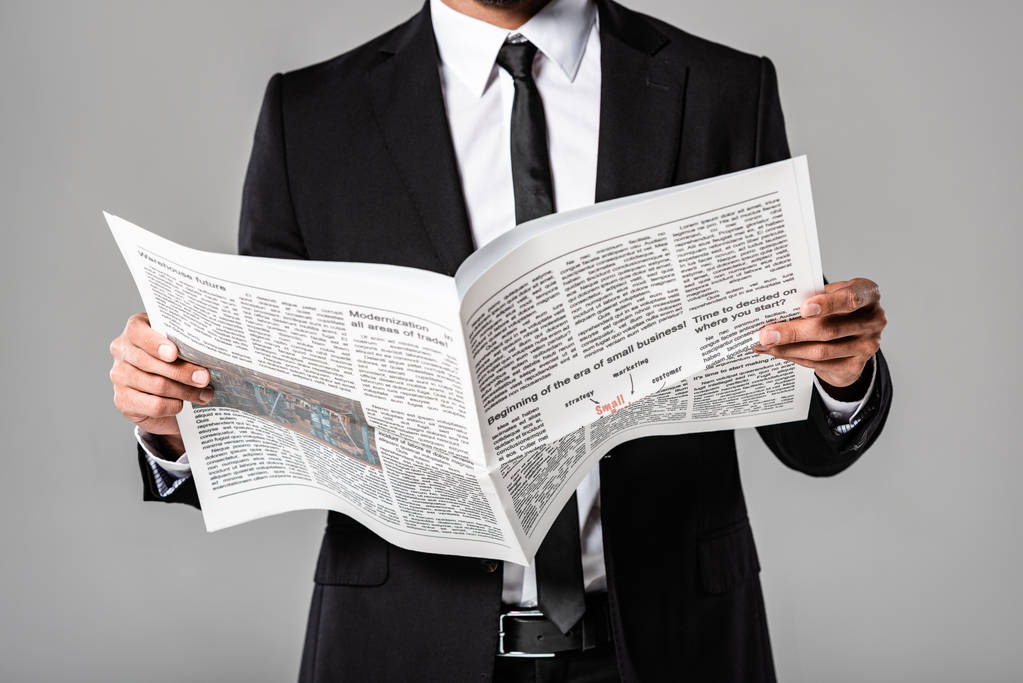 osittainen näkymä liikemies musta puku sanomalehti eristetty harmaa
 - Valokuva, kuva