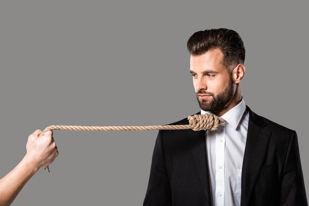 depressed businessman in black suit with noose on neck looking at murderer with rope isolated on grey - Photo, Image
