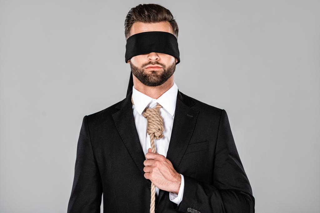 Mit verbundenen Augen Geschäftsmann im schwarzen Anzug mit Schlinge um den Hals isoliert auf grau - Foto, Bild
