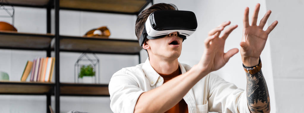 Panoramaaufnahme eines Mannes mit Virtual-Reality-Headset in Wohnung  - Foto, Bild